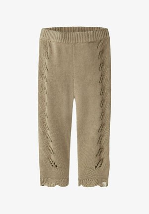 Beige strikkede babybukser med ribstrikket taljebånd og dekorative hulmønstre, der løber vertikalt ned ad begge ben.