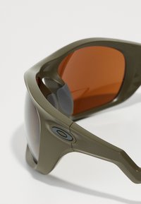 Sportsonnenbrille mit einem olivgrünen Kunststoffrahmen, orange getönten Gläsern und grauen Gummi-Akzenten für Komfort und Grip.