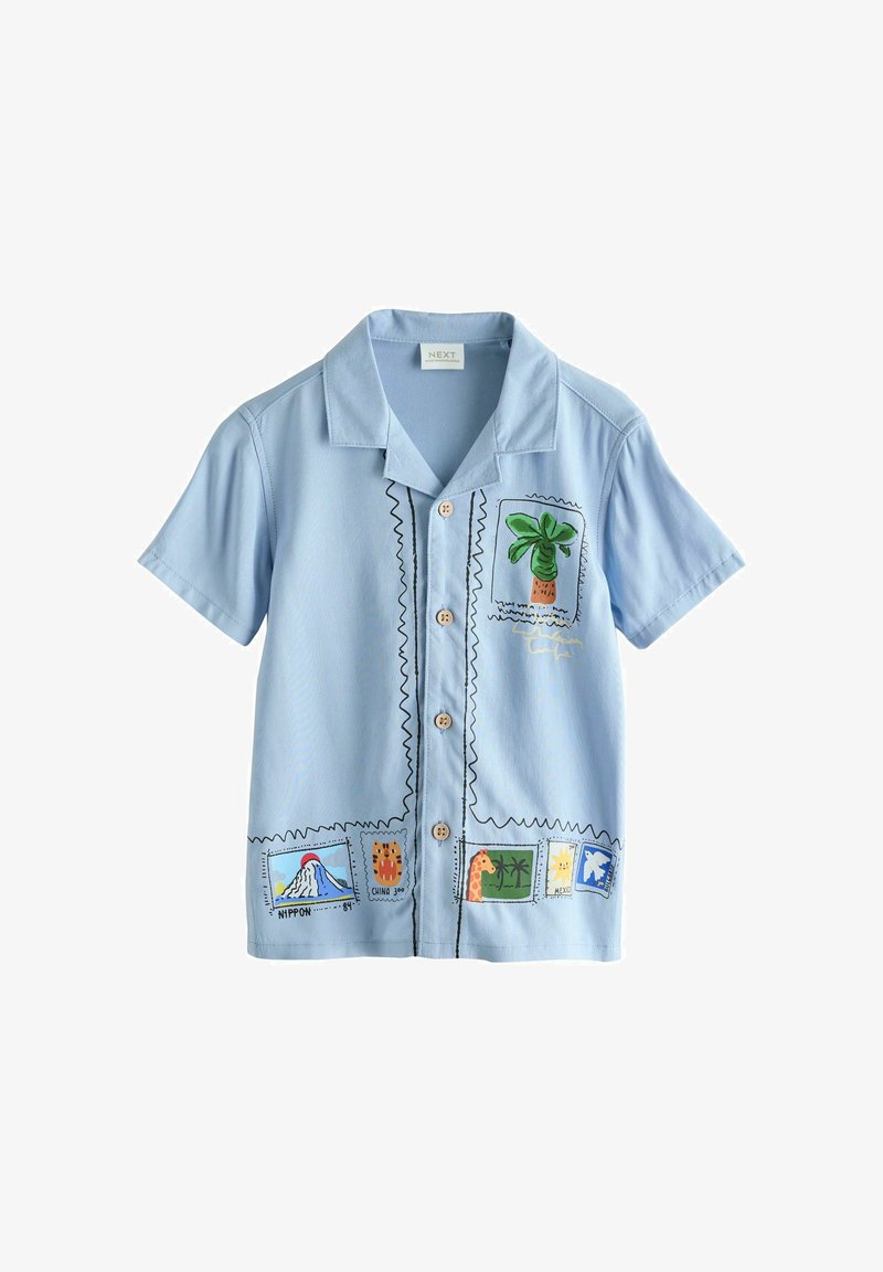 Chemise à manches courtes bleu clair avec des imprimés colorés de tampons sur le thème du voyage, comprenant un palmier, un volcan et une girafe.