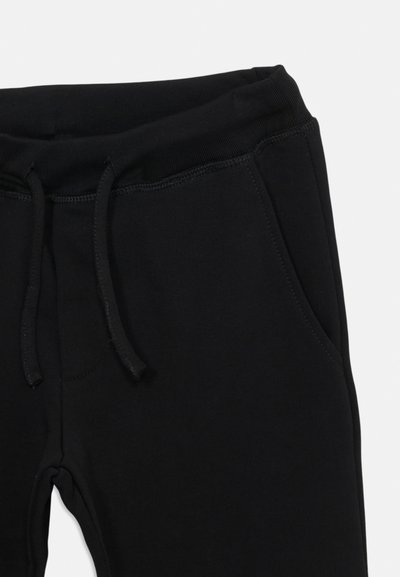 Schwarze Jogginghose mit einem Kordelzugbund, zwei seitlichen Taschen und einem weichen, strukturierten Stoff. Einfaches Design mit genähten Nähten.