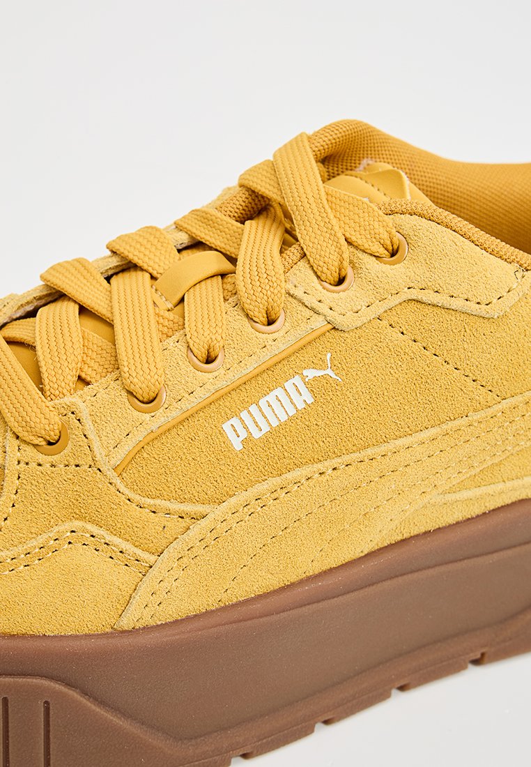 Zapatillas de ante amarillas con cordones planos, suela de goma y un logo blanco. Cuenta con un collar acolchado y acentos perforados en los laterales.