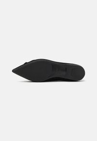 Pantof de piele de nubuc negru cu toc înalt, cu vârful ascuțit și talpă din cauciuc neted, având un design elegant și minimalist.