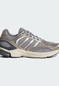 Grey mesh running shoe featuring silver accents, a thick sole, and a cushioned design with prominent branding on the side.