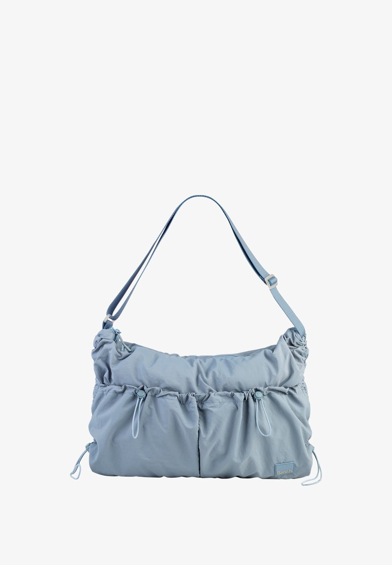 Sac à main en tissu bleu clair avec une texture froncée, bandoulière réglable, deux poches avant et des détails à cordon sur les côtés.