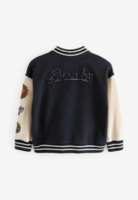 Navy Bomberjacke mit hellen Ärmeln, besticktem "Superdry" auf dem Rücken, gestreiftem Rippkragen und -bündchen, ausgestattet mit verschiedenen bunten Aufnähern.