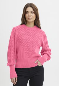 Rózsaszín kötött pulóver ribbelt mandzsettákkal és aljjal, texturált geometrikus mintával és hosszú ujjakkal.