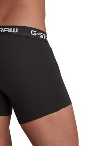 Boxer in cotone nero con design aderente. L'elastico presenta il marchio bianco "G-STAR", mostrando una texture liscia.
