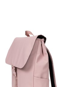 Pink backpack with a flap closure, made of smooth material. Features adjustable straps, a side pocket, and a top handle for carrying.