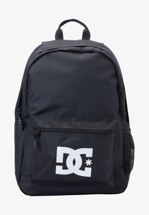 Mochila negra hecha de un tejido duradero con un bolsillo frontal con cremallera y un bolsillo lateral de malla; presenta un destacado logo blanco de DC.