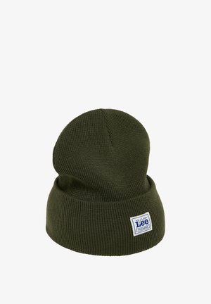 Zielona dziana czapka beanie z podwiniętym brzegiem, z naszytą niebiesko-białą łatą z logo. Miękka tekstura i prosty design.