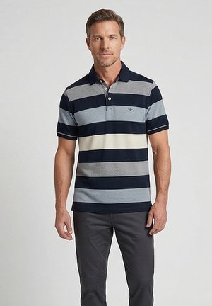 Homme portant un polo à manches courtes avec col, à rayures horizontales bleu marine, gris et blanches, et un pantalon gris foncé, debout sur un fond uni.
