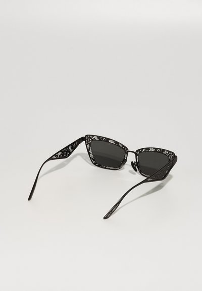 Black lace sunglasses with triangular lenses, intricate cut-out designs, and silver accents along the edges, featuring slender straight arms.