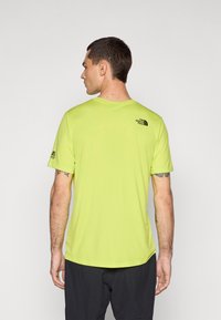 T-shirt athlétique à manches courtes en néon vert. Doté d'un col rond, d'un tissu respirant et de détails de logo noirs au dos et sur la manche.