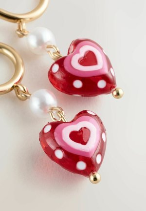 Red and pink heart-shaped earrings with white polka dots, gold hardware, and a pearl bead accent. Glass material with layered designs.