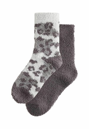 Et par bløde crew sokker, den ene ensfarvet mørkegrå og den anden hvid med mørkegrå leopardpletter.