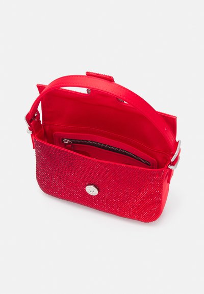 Sac à main rouge avec une surface texturée et scintillante, des accessoires en métal argenté, une bandoulière amovible et une poche zippée à l'intérieur. Le design ouvert met en valeur l'intérieur.