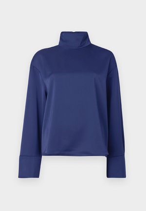 Navy blue long-sleeve top with a high mock neck. Made of smooth fabric, features raglan sleeves and cuffed hems. Simple, unembellished design.