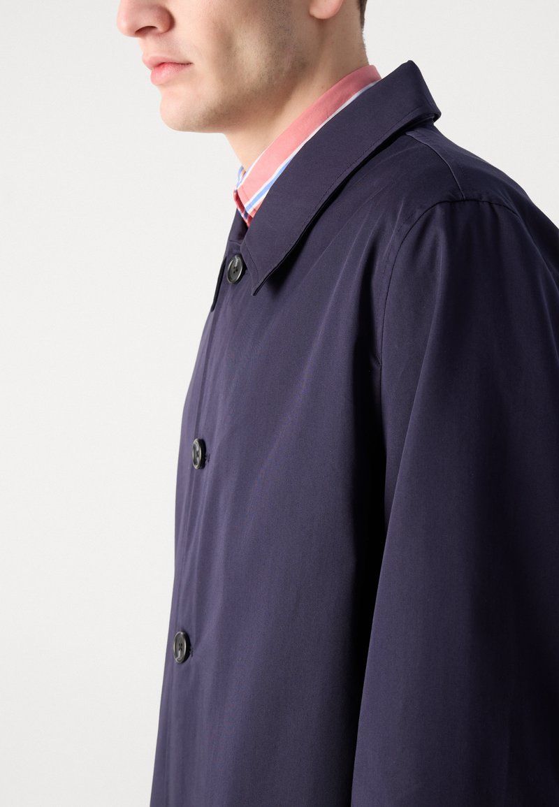 Granatowy płaszcz z dopasowanym kołnierzem i trzema guzikami z przodu. Gładki materiał o jednolitej strukturze, prezentowany z boku.