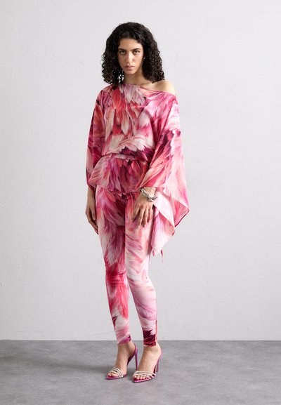 Top off-shoulder con motivo floreale e leggings in diverse tonalità di rosa; tessuto strutturato. Sandali con tacco alto rosa con accenti metallici.