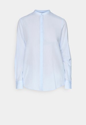 Lys blå langermet skjorte med ståkrage, frontlukking med knapper og buet kant. Stoffet har en glatt tekstur og en subtil glans.