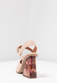 Teplákové kožené sandály v broskvové barvě s masivním mramorovým hnědým blokovým podpatkem. Obsahují nastavitelný pásek a hladký vnitřek pro pohodlí.