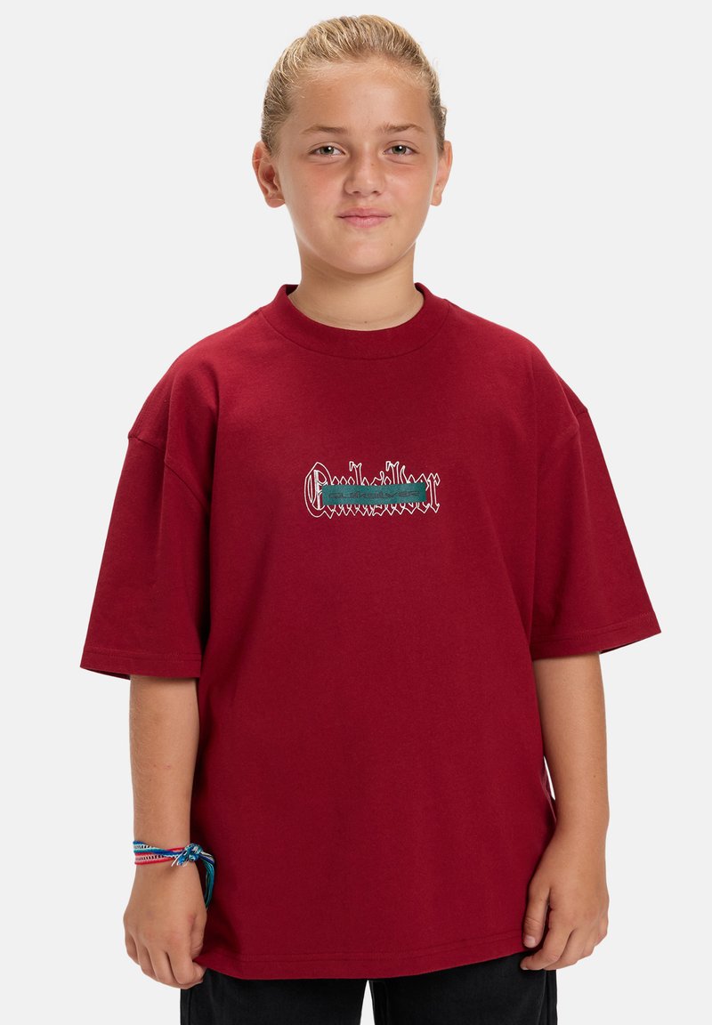 Rode oversized t-shirt met een ronde hals, met geborduurde groene en witte tekstontwerpen op de voorkant. Korte mouwen, van katoen.