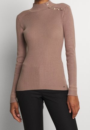 Haut mauve à manches longues en maille côtelée avec col montant et boutons décoratifs sur l'épaule, porté avec un pantalon noir.