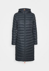 Foret mørkeblå frakke med hætte, udstyret med lynlås, lange ærmer og orange lynlåstrækker. Quiltet design med vandrette sømme.