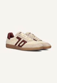 Beige sneakers met een textuur van pluizig bovenwerk, bordeauxrode accenten en logo. Heeft een lage ontwerp en rubberen zool. Veters in een traditionele stijl.