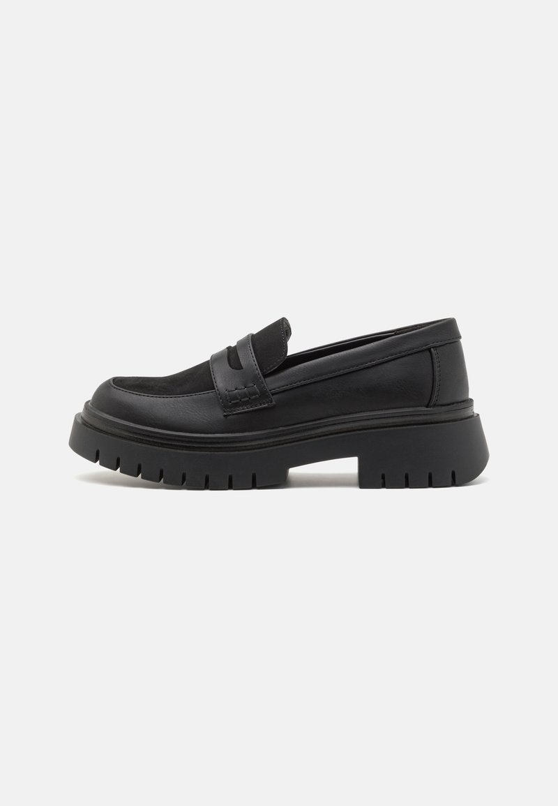 Mocassins en cuir noir avec une semelle épaisse et crantée, dotés d'un embout arrondi et de deuxstraps décoratifs sur le dessus. Texture lisse.