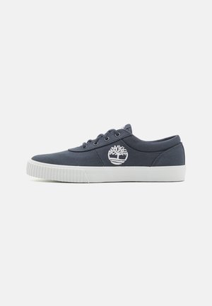 Marineblauwe canvas sneakers met een witte rubberen zool, voorzien van een witte geborduurde boomlogo aan de zijkant en veterbinding met vier oogjes.