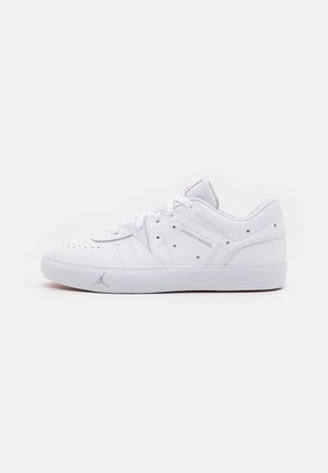 Niski biały skórzany sneaker z sznurowadłami, perforacjami i subtelnym logo Jordan po boku i na podeszwie na jednolitym tle.