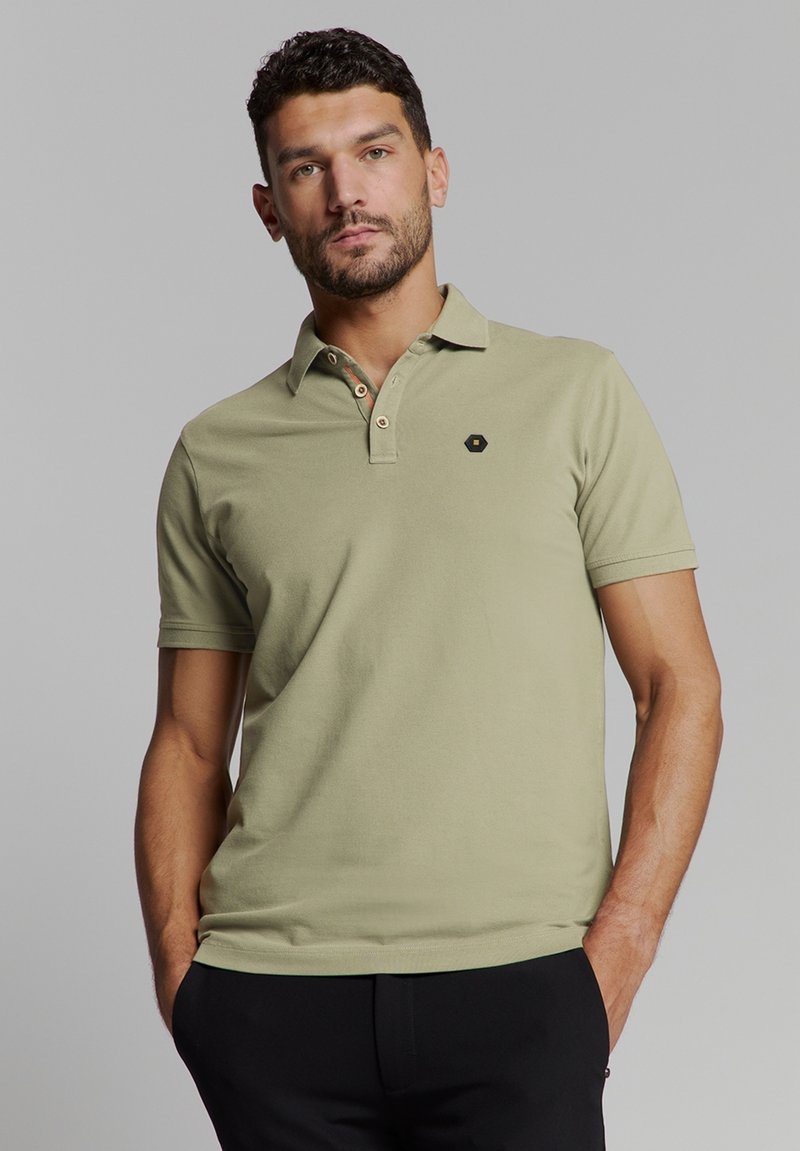 Khaki poloshirt van katoen, met een korte kraag, een drieknopsluiting met contrasterende knopen en een klein zwart embleem op de borst.