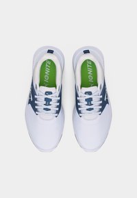 Ζευγάρι λευκά και ναυτικά αθλητικά παπούτσια με πράσινα πέλματα επωνομαζόμενα "IGNITE", σε θέα από πάνω σε λευκό φόντο.