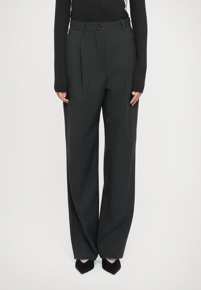 Pantalons plissés gris foncé à motif rayé, fabriqués dans un tissu texturé, avec une fermeture à bouton et des poches latérales.