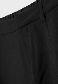 Crne hlače s elastičnim strukom i glatkom teksturom, s bočnim džepovima i čistim linijama za krojeni izgled.