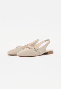 Beige suede slingback shoes with a pointed toe, a strap across the forefoot, and a small silver buckle detail. Flat wooden heel.