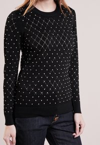 Czarny sweter dzianinowy z motywem diamentów, ozdobiony metalicznymi koralikami, z długimi rękawami oraz ściągaczem przy dekolcie i dolnej krawędzi.