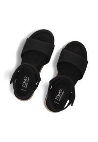 Zwarte sandalen met brede stoffen banden en een zachte suede voetbed. Opvallende stiksels en TOMS-logo op de binnenzool.