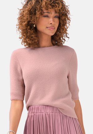Light pink short-sleeve sweater in a textured knit, paired with a pleated pink skirt. Sweater features a rounded neckline and slight side hem.