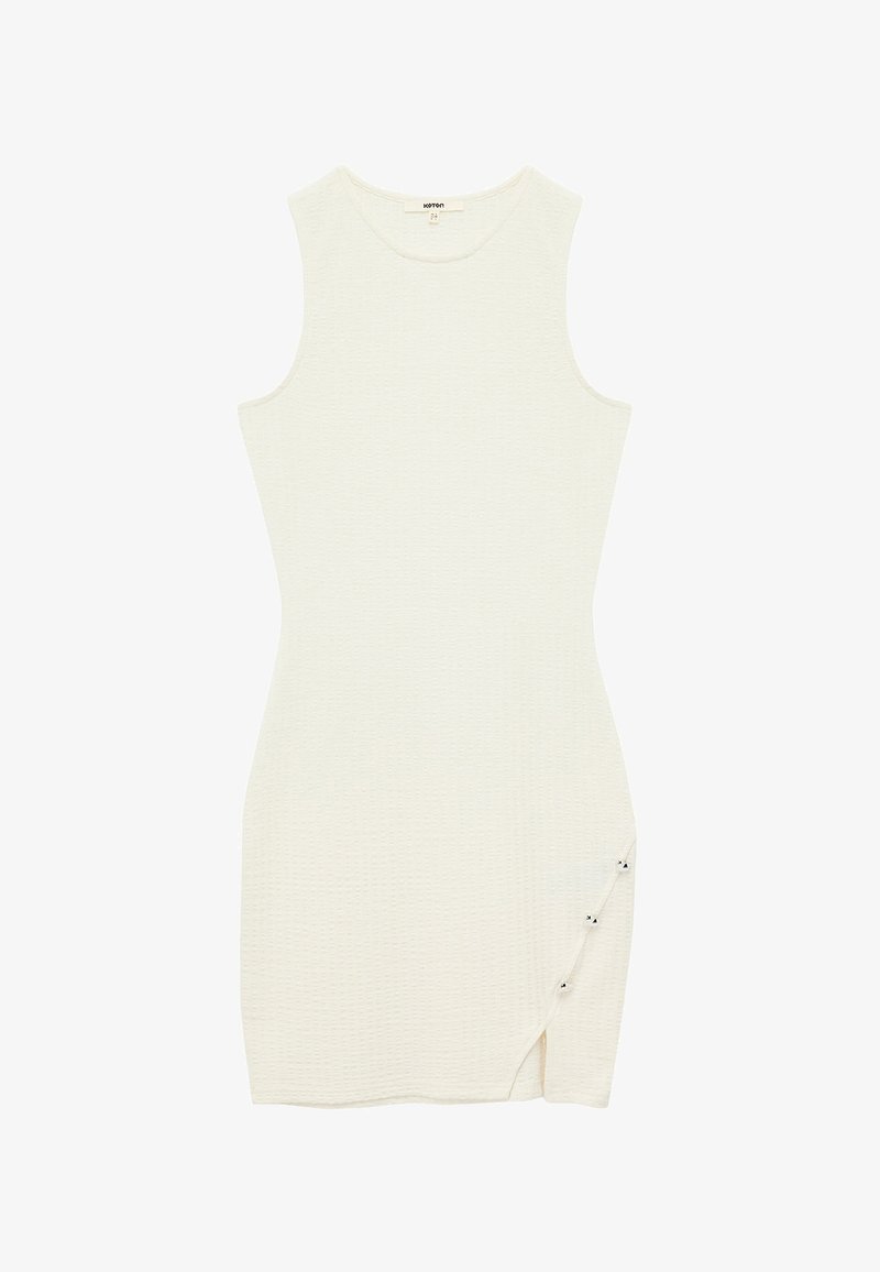 Robe moulante blanche sans manches avec un tissu texturé, comportant une fente sur le côté et trois boutons décoratifs le long de l'ourlet pour le détail.
