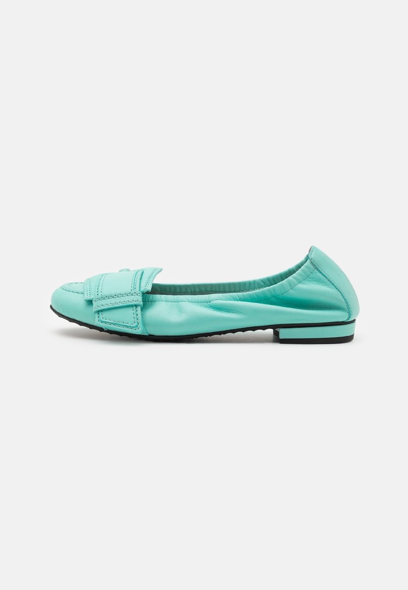 Ballerine en cuir vert menthe avec talon bas et sangle décorative cousue traversant l'avant arrondi, vue latérale sur fond blanc.