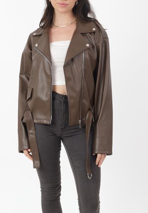 Bruine bikerjack van nepleer met een getailleerd ontwerp, zilverkleurige hardware, een ritssluiting aan de voorkant, brede revers en een strikdetail in de taille.