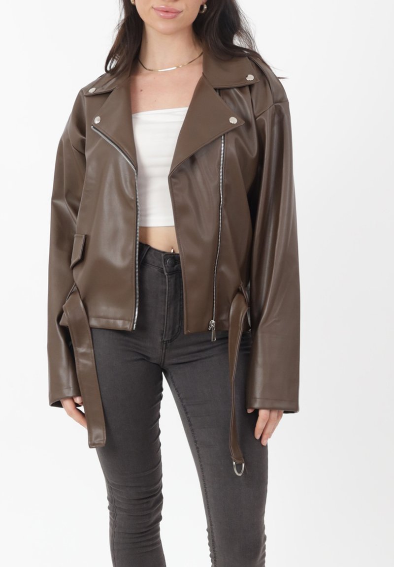 Brązowa kurtka motocyklowa z imitacji skóry o dopasowanym kroju, srebrnymi elementami, zamkiem błyskawicznym z przodu, szerokimi klapami i wiązaniem w talii.