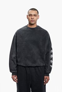 Charcoal sweatshirt with a relaxed fit, ribbed neckline, and long sleeves featuring a white floral graphic on the left sleeve.