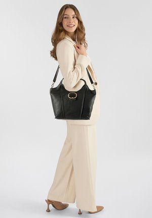 Bolso de mano de cuero negro con diseño estructurado, que presenta un destacado detalle dorado en la parte frontal. Incluye una correa ajustable para el hombro.