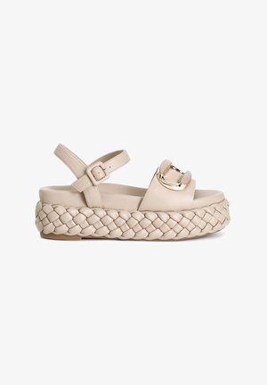 Beige platform-sandaalit, joissa on punottu nahkapohja, leveä nauha ja kultainen solki. Säädettävä nilkkaremminen sopivuuden takaamiseksi.