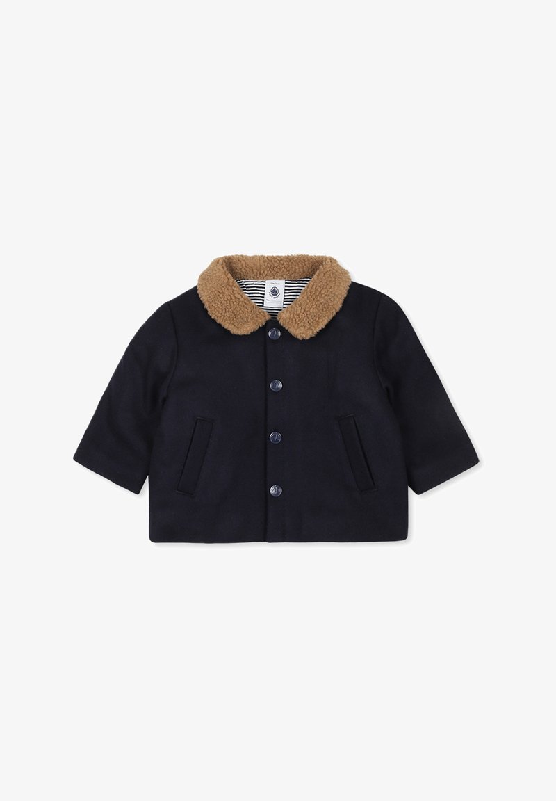 Veste bleu marine avec un col en polaire beige. Présente des manches courtes, deux poches avant et une fermeture à bouton. Tissu texturé.