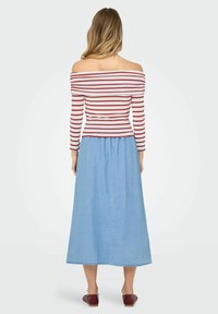 Off-shoulder rød og hvid stribet top parret med en lys blå denim maxi nederdel. Outfitet har en tætsiddende overdel og en udsvingende nederdel.