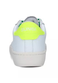 Sneaker bianca con tomaia in pelle liscia. Presenta un supporto sul tallone di un brillante giallo fluorescente con il testo "SUN68" e una suola in gomma bianca.